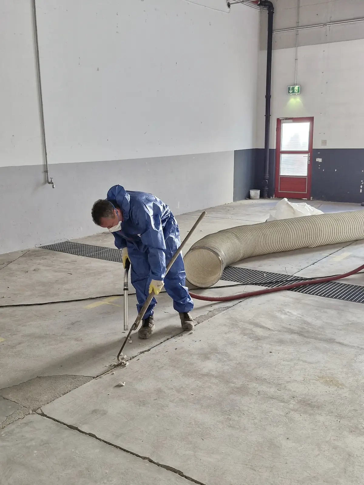Facharbeiter beim Bodenabtrag in einer Industriehalle