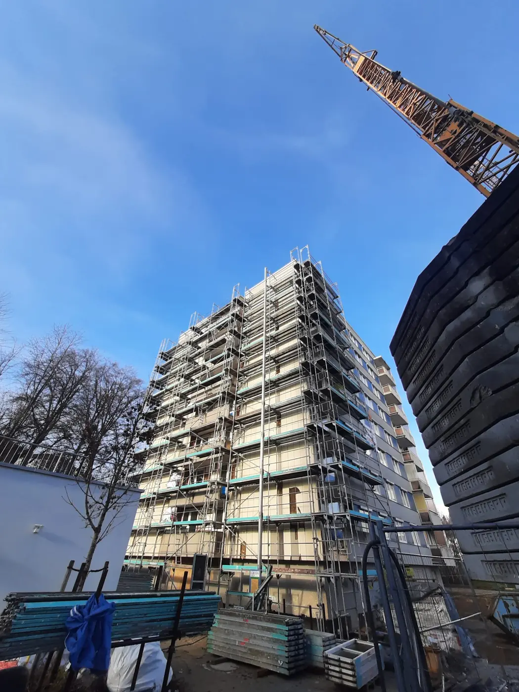 Seitliche Ansicht des eingeruesteten Wohnblocks bei der Asbestfassaden-Sanierung in Deggendorf